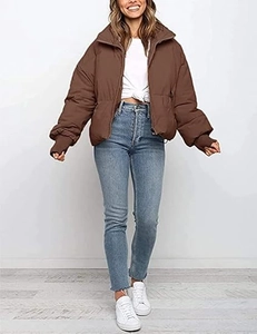 Detail of a brown puffer jacket with ribbed windproof cuffs and casual denim styling