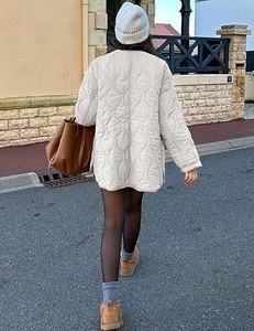 Rear view of a cream quilted jacket featuring wave patterns and loose fit for autumn street style