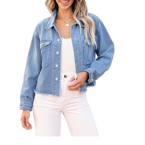 Detail of light blue denim jacket with frayed hem and metallic buttons for a casual look