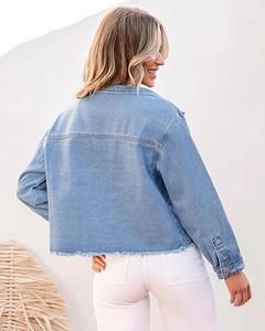 Detail of light blue cropped denim jacket with raw hem edge and back stitching