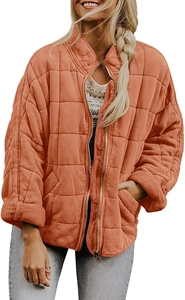 Détail de la veste matelassée orange montrant la fermeture éclair et la poche latérale