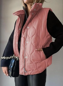 Detail of dusty rose quilted vest featuring wavy stitching and secure zipper closure