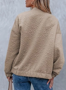 Detailed back view of a khaki quilted jacket with floral embossed daisy texture pattern