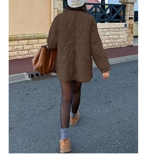 Back view of a long dark brown quilted jacket with wave patterns and a collarless design