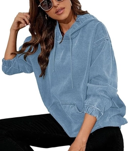Close-up of vintage washed blue denim hoodie with kangaroo pocket and oversized fit