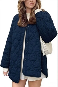 Detailed close-up of wave quilted navy jacket with metallic snap buttons and collarless neck