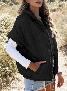 Detail of a black quilted puffer vest featuring a stand-up collar and front zip closure