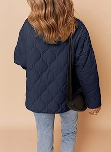 Macro view of navy blue diamond quilting and loose shoulder cut on a women's jacket