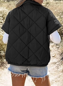 Back view of black quilted puffer vest with diamond pattern and elastic hem on a model