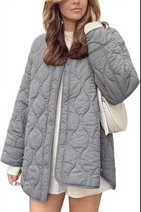 Detail of grey diamond quilted jacket featuring button closure and ribbed cuffs design