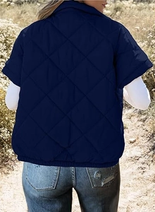 Detail view of the back of a navy blue quilted vest with large diamond stitching pattern