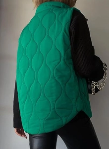 Macro detail of a bright green quilted vest with wave stitching on the back side view