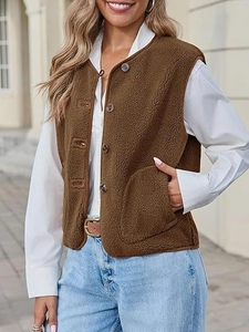 Detail of brown faux shearling vest featuring brown buttons and large patch pockets
