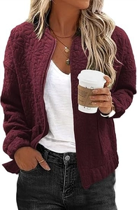 Detailed view of the textured sunflower relief pattern on the burgundy quilted jacket