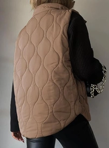 Detailed back view of khaki quilted vest with classic onion stitching and stand collar