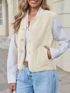 Close-up detail of cream faux shearling vest featuring brown buttons and soft fuzzy texture