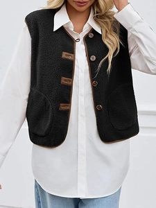 Detail of faux shearling vest featuring brown leather buckles and circular pockets