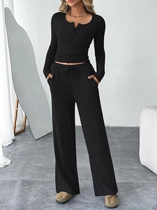 Detailed texture of black ribbed knit lounge set featuring long sleeve button top and pants