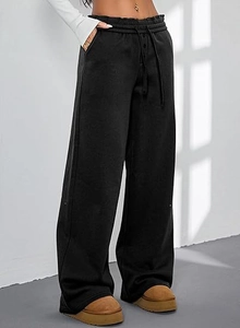 Detail einer schwarzen weiten Jogginghose mit hohem Bund, Kordelzug und praktischen Taschen