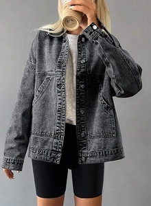 Close-up of dark grey washed denim jacket featuring metal buttons and retro texture