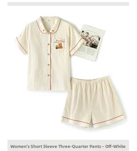 Detail of cotton pajama set showing bear embroidery and orange piping on short sleeve top