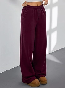 Details einer burgunderroten Jogginghose mit hoher Taille, Zierknöpfen und elastischem Bund