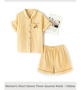 Detail view of yellow cotton pajama set with cute bear embroidery and vertical stripes