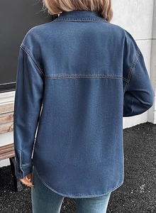 Detail view of the back seams and curved hem on a dark blue washed denim shirt