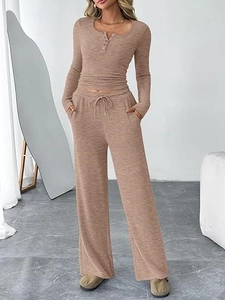Detailed close-up of knitted two-piece set featuring long-sleeve henley top and wide-leg pants