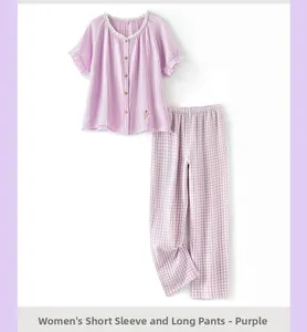 Détail d'un pyjama en gaze de coton lilas avec broderie florale et bordures en dentelle