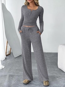 Detail of grey ribbed two-piece set featuring henley neck top and drawstring wide-leg pants