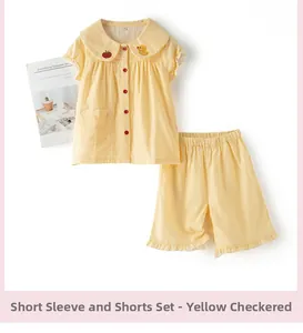 Détail d'un pyjama enfant en vichy jaune avec broderies de pomme et de caneton