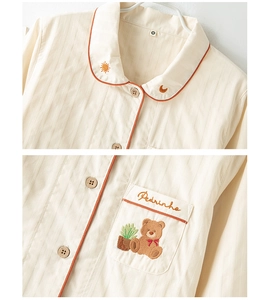 Close-up of cotton sateen pajama top with bear embroidery and orange piped collar