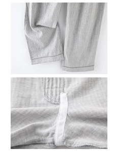 Dettaglio dei pantaloni del pigiama in cotone a righe grigie con cuciture fini e nastro bianco