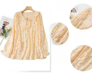 Détail d'un pyjama en coton avec col à volants et imprimé cerise sur tissu à carreaux