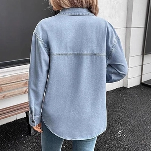 Women's light blue washed vintage denim shirt with long sleeves and curved hem back view