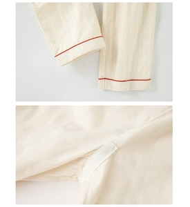 Detail of light beige cotton pajama fabric with red contrast piping and stitching