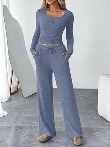Detail of blue-grey knit set featuring buttoned neckline and drawstring wide-leg pants