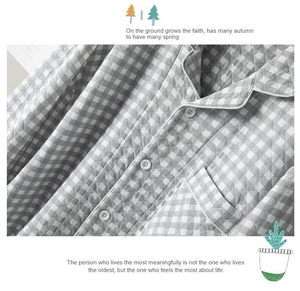 Detail view of grey quilted plaid pajamas featuring a classic lapel and white buttons