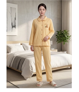 Full-length view of yellow cotton bear pajama set in a cozy minimalist bedroom setup