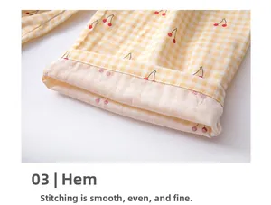 Detailed view of the stitched hem on yellow plaid cotton pajama pants with cherry print