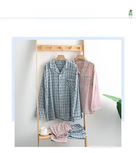 Détails d'un ensemble de pyjama en coton à carreaux bleu et rose suspendu sur bois