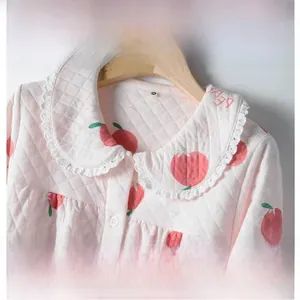 Detail of pink quilted pajama set with red apple prints and white lace Peter Pan collar