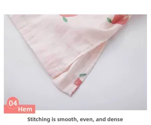 Detail view of pink cotton gauze pajama hem with cherry print and neat side slit stitching