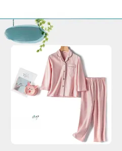 Flat lay of girl's pink plaid cotton pajama set with button-down top and trousers