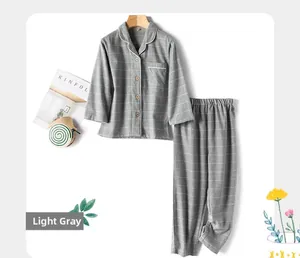 Detail of light grey plaid cotton pajamas with white piping and chest pocket