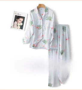 Détail de pyjama bleu en coton avec motif flamant rose et nœud en dentelle blanche