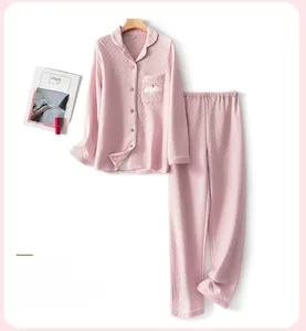 Detail of pink quilted pajama set showing diamond pattern texture and bird embroidery