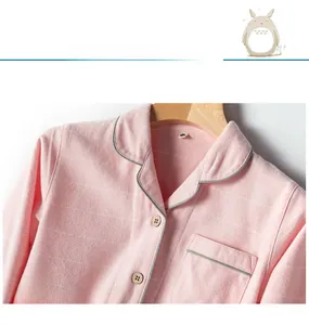 Close-up of pink cotton pajama collar with gray piping and wooden buttons detail