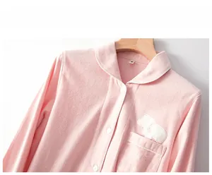 Detail der weichen rosa Baumwoll-Pyjamas mit süßer Pilzstickerei und weißer Paspelierung